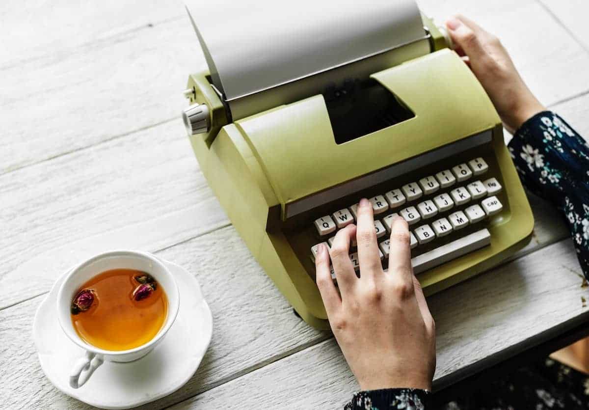 Woman typing on a vintage green typewriter