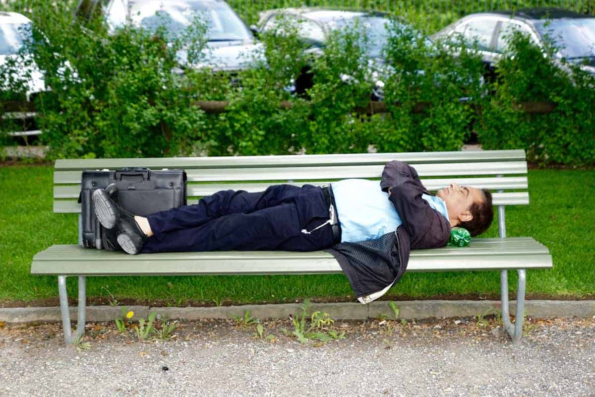 business man sleeping on a bench