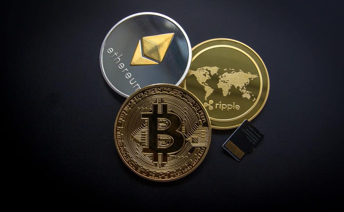 physical cryptocurrency coins against a black background-min