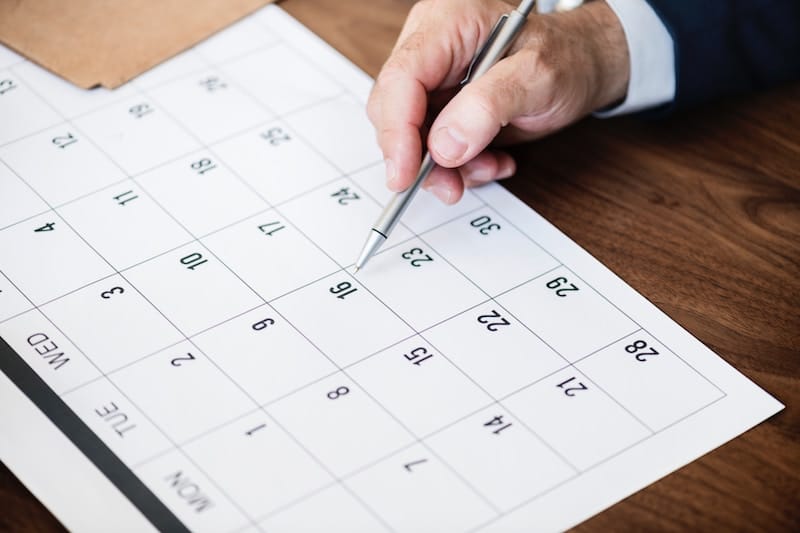 Man Looking over a calendar to see what is scheduled