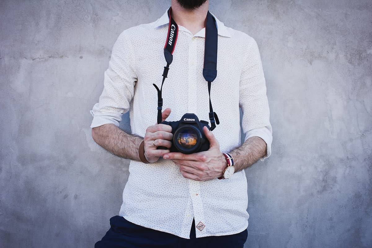 Man Wearing White Long Sleeves Holding Black Canon Dslr Camera