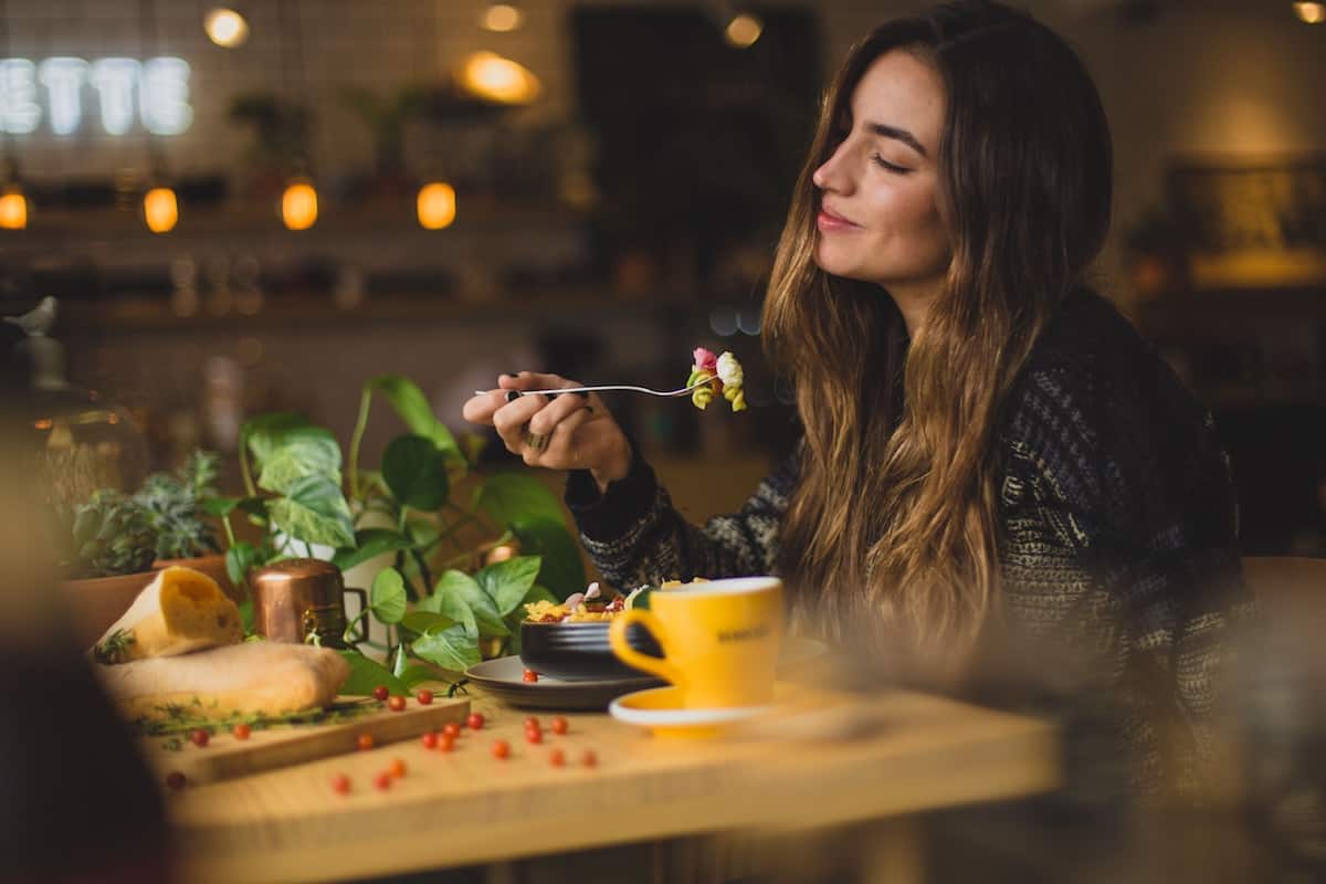 Woman sitting inside a modern restaurant and enjoying her meal