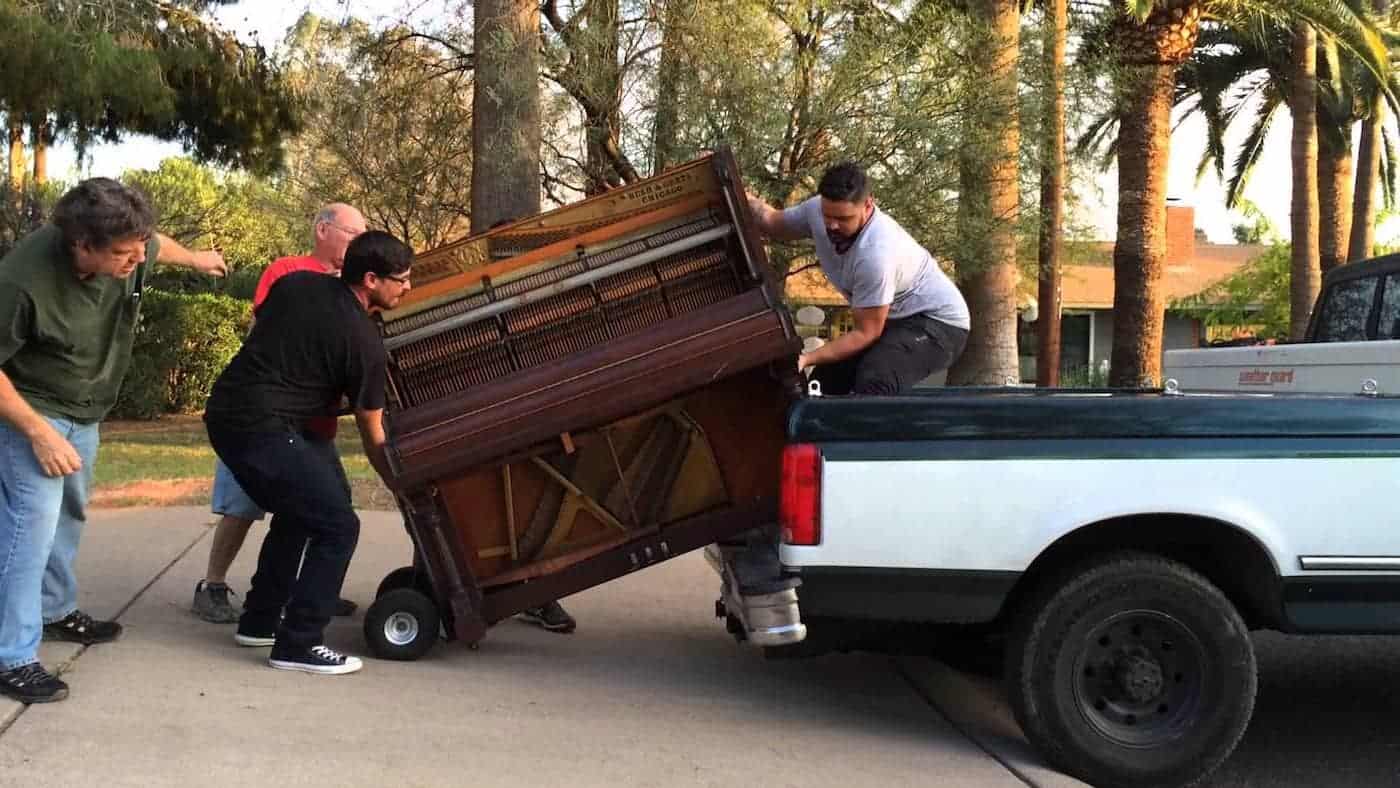 Four men moving a piano