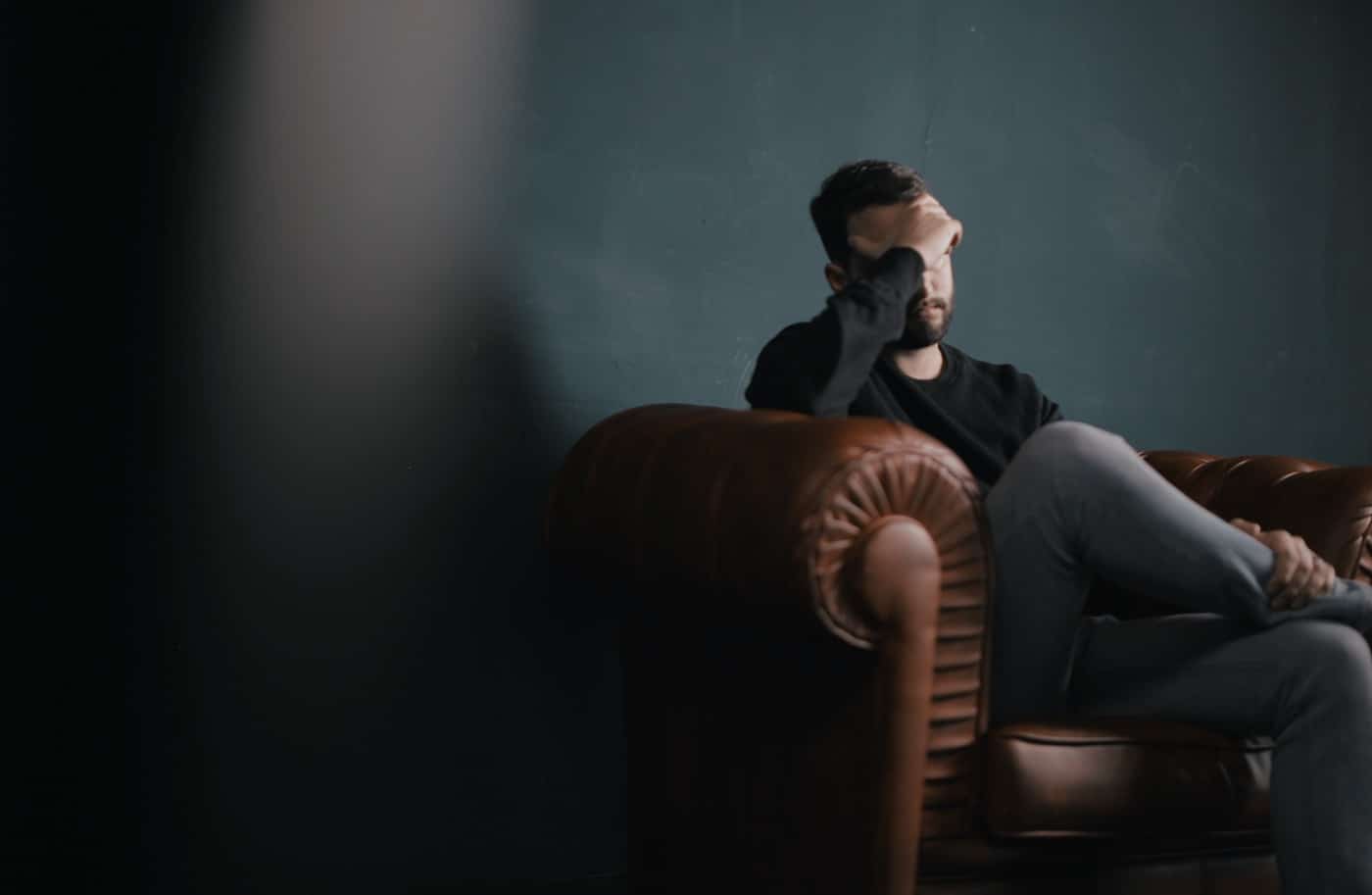 Stressed man sitting on a sofa chair