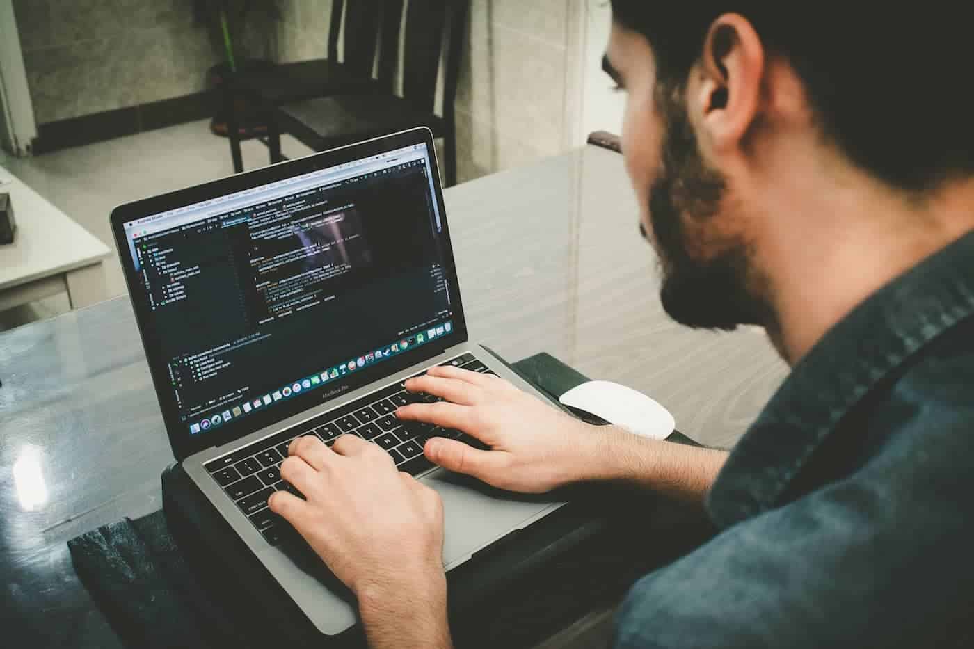 Man writing code on his laptop