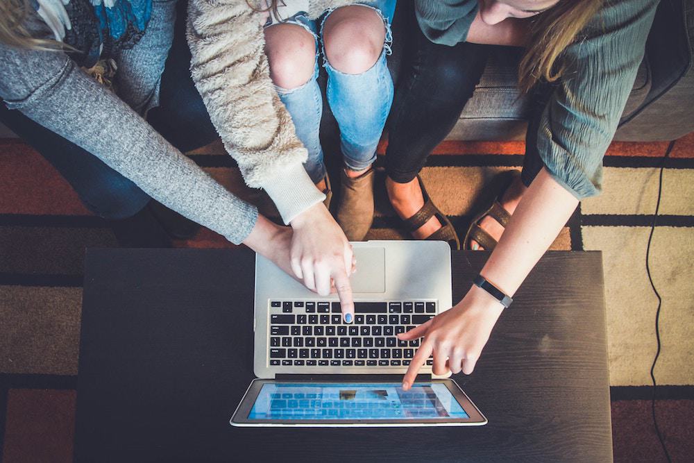 People Pointing at a website on a laptop