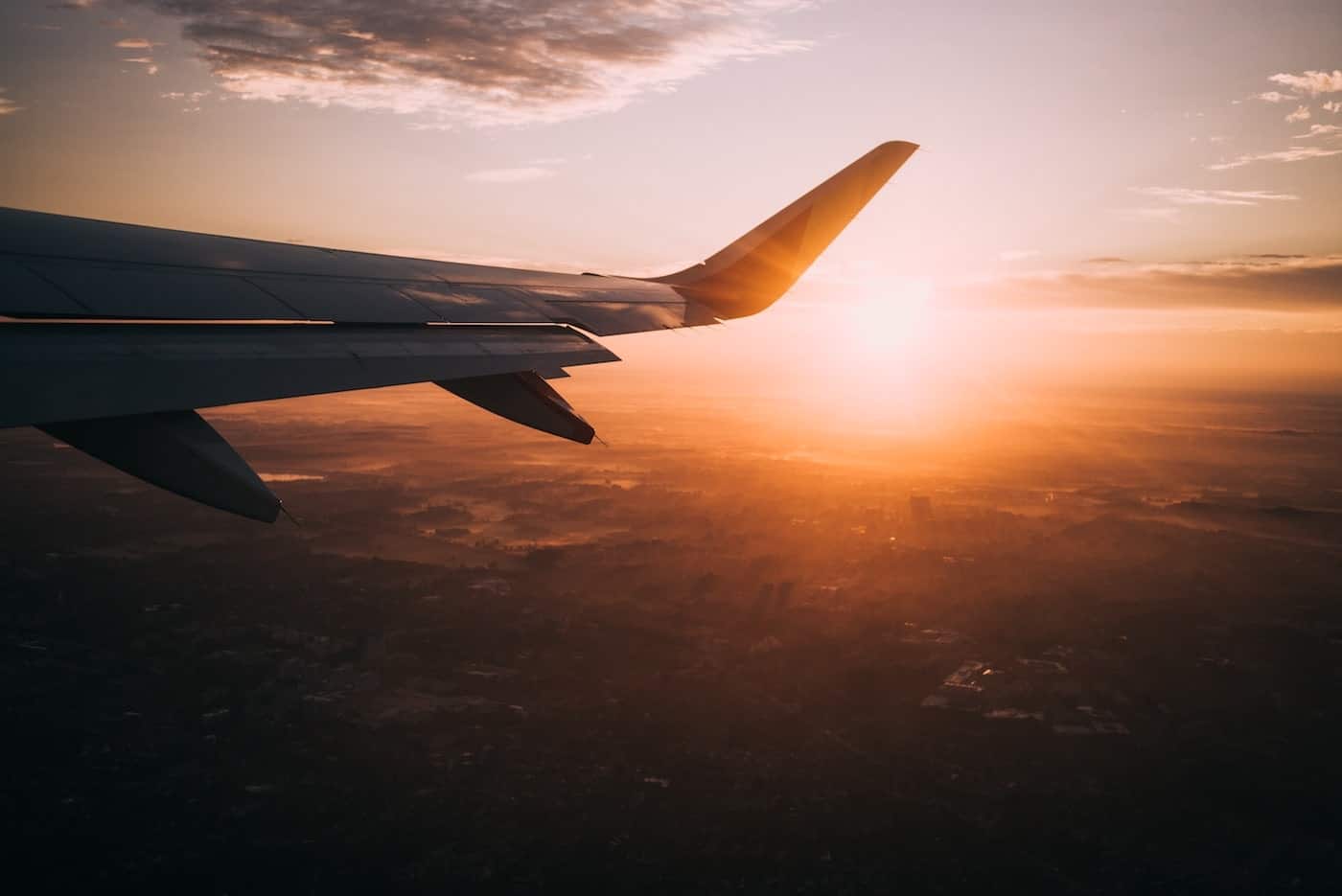 Photo of an Airplane Wing During Sunset