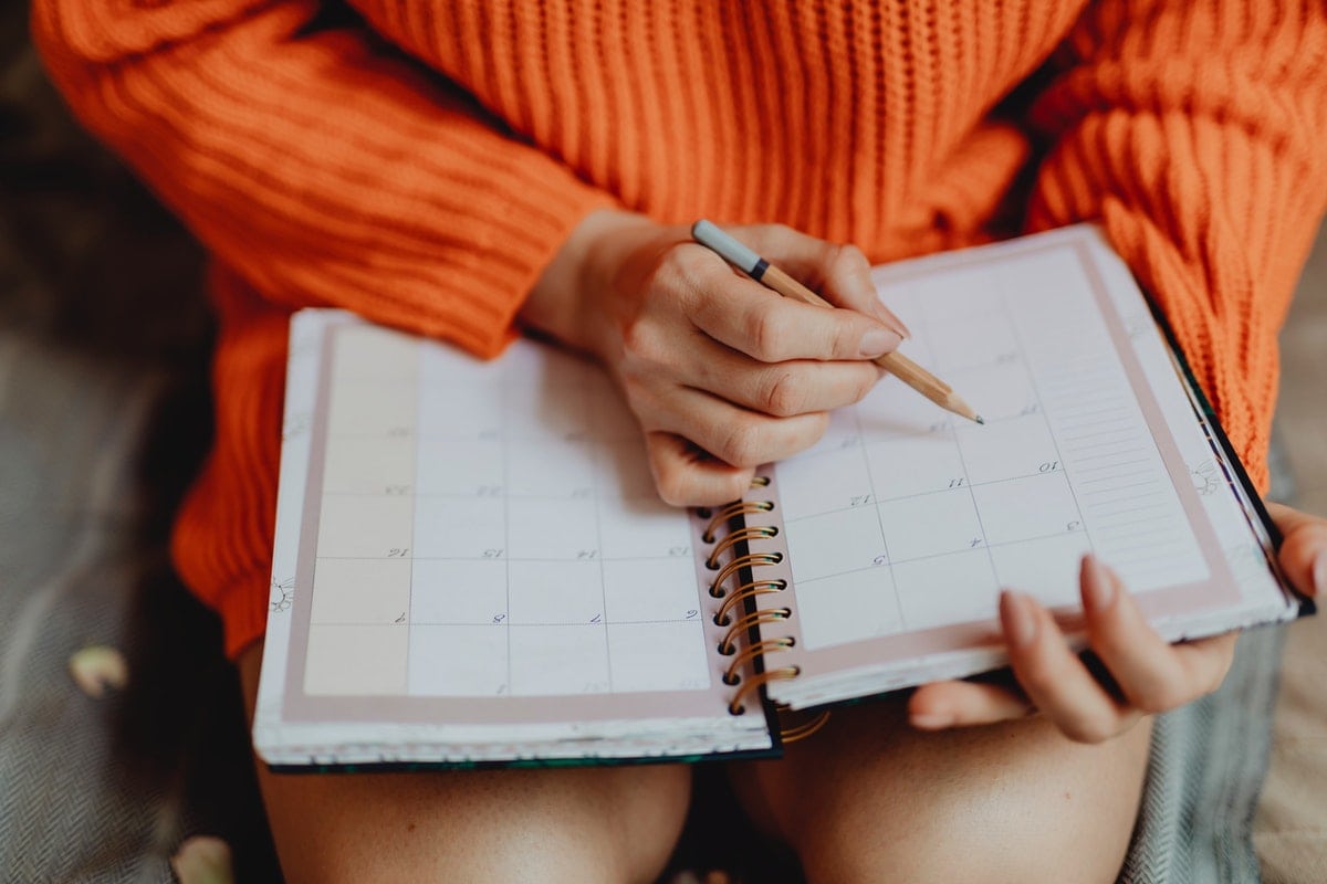 Woman Scheduling Events in Her Notebook