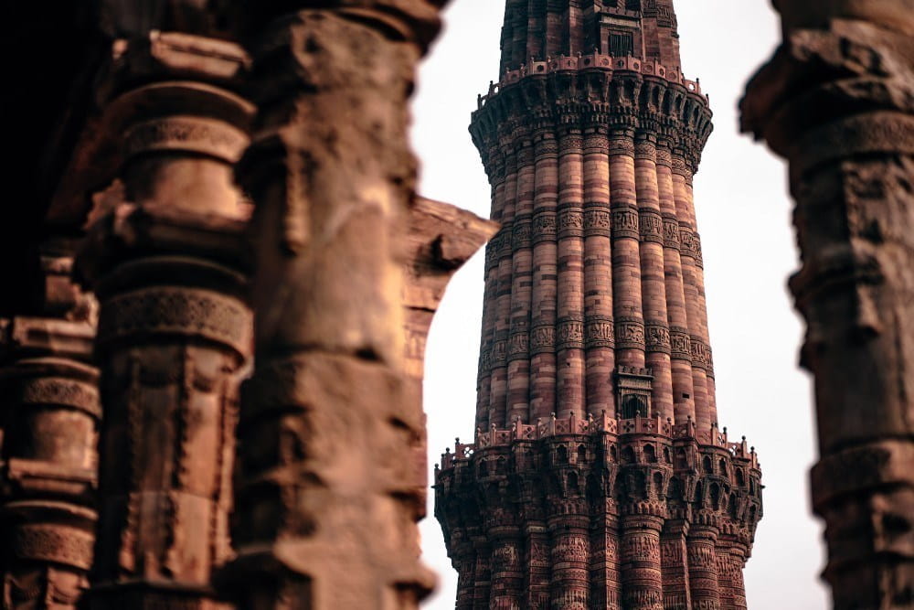 The Amazing Qutub Minar Seen Through the Pillars of a Jain Temple
