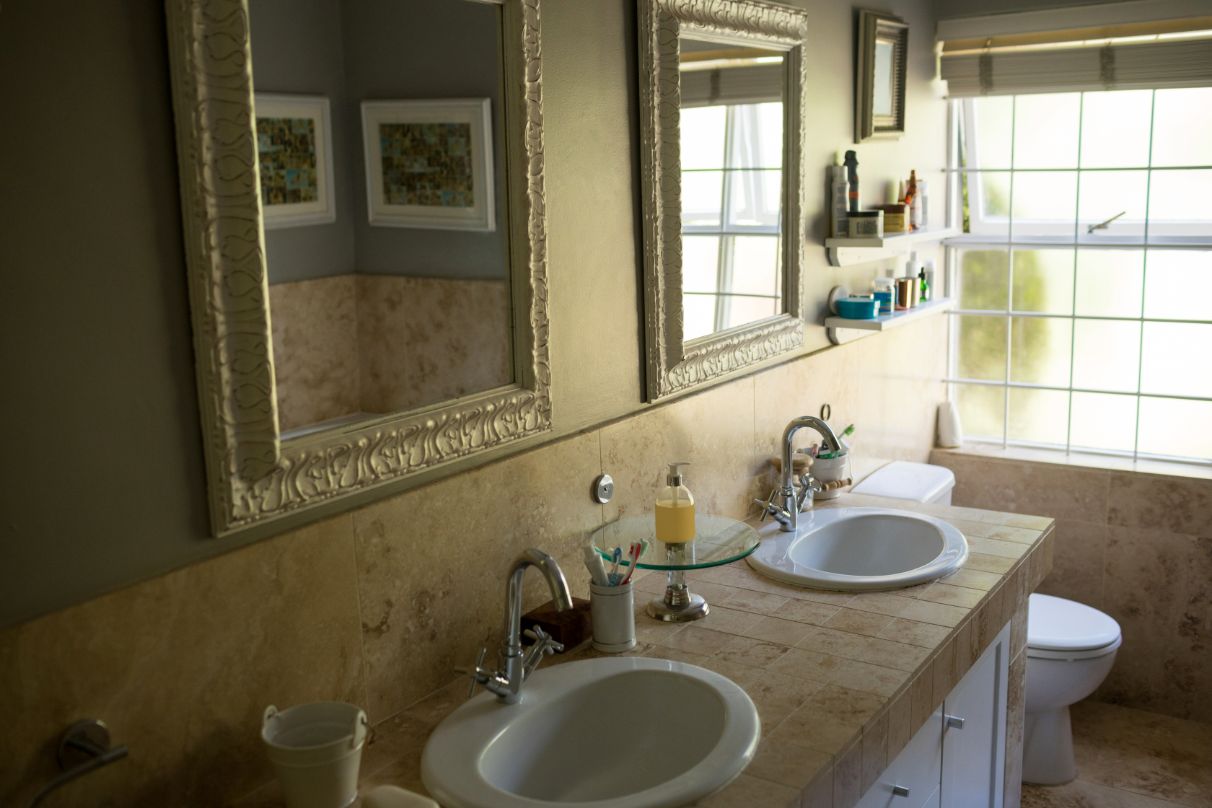 bathroom mirror over sink and toilet