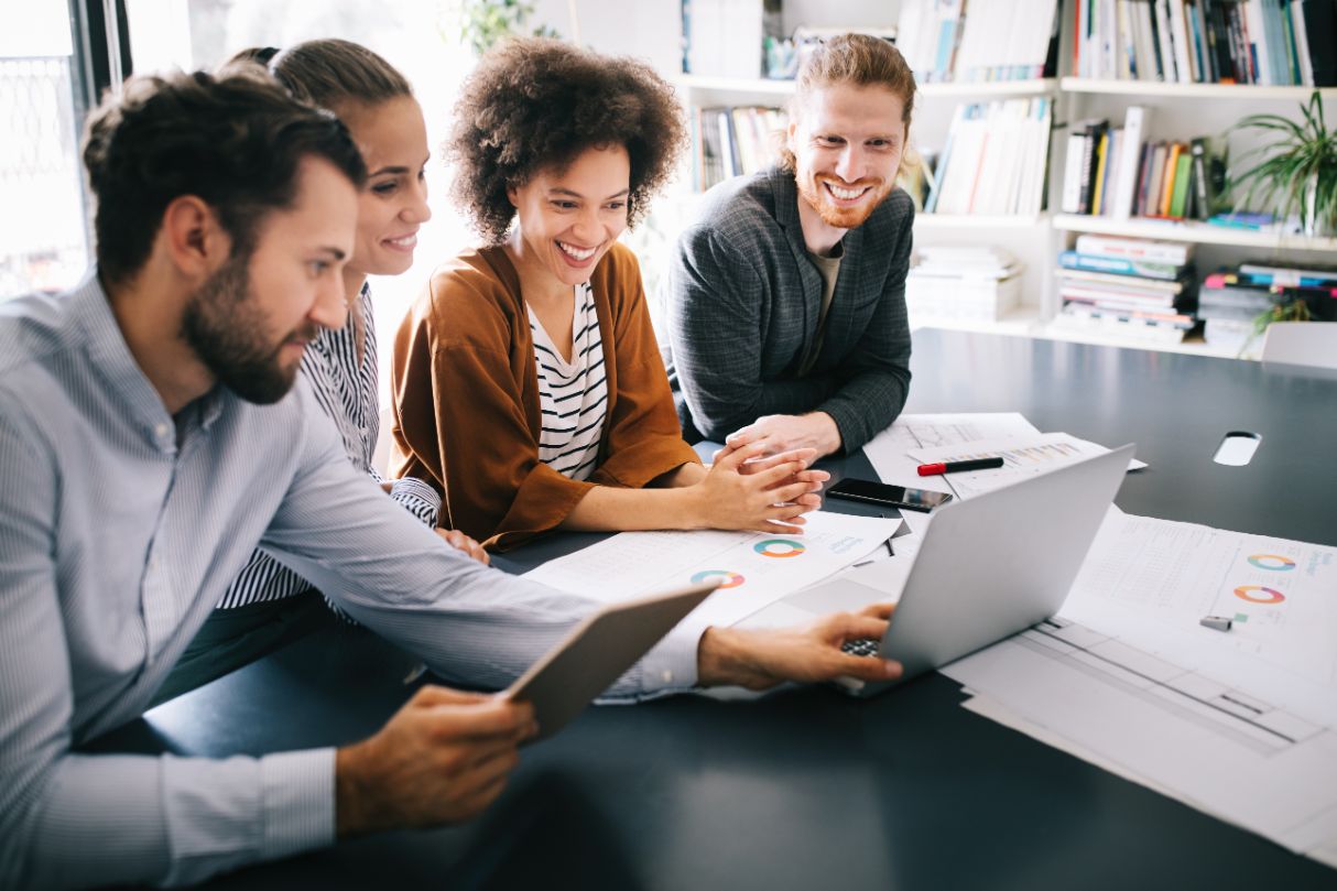 group of diverse employees working together in front of a computer