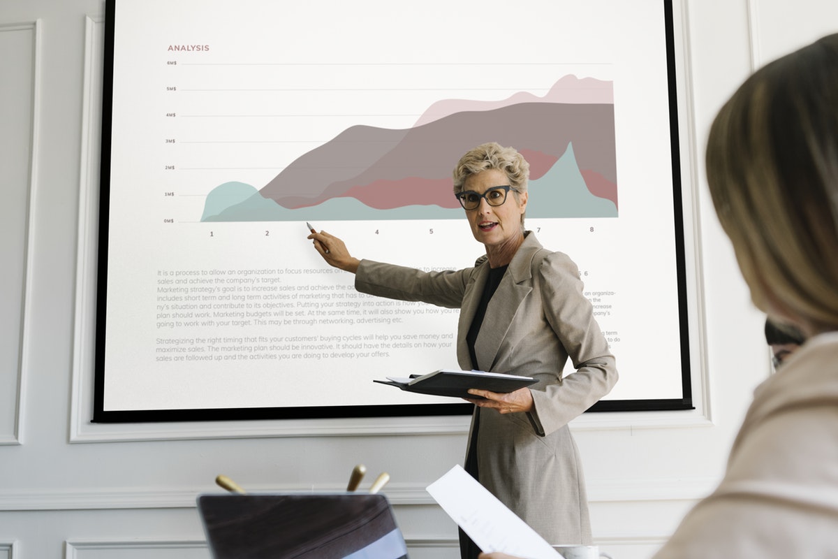 Blonde aged woman giving a presentation 