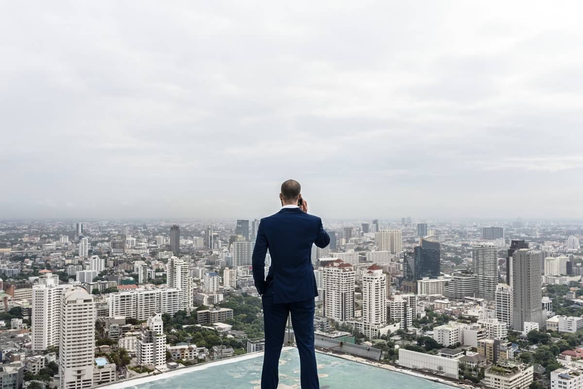 Business man talking on a phone with a cityscape background