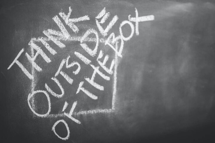 Think outside the box quote on the blackboard