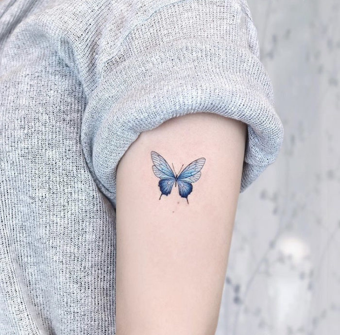 Blue butterfly tattoo on the forearm