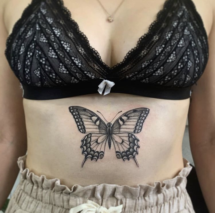 Tattoo of a butterfly located on the sternum