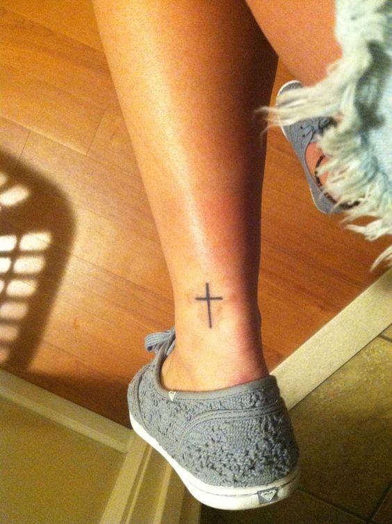 Minimalist cross tattoo on the ankle