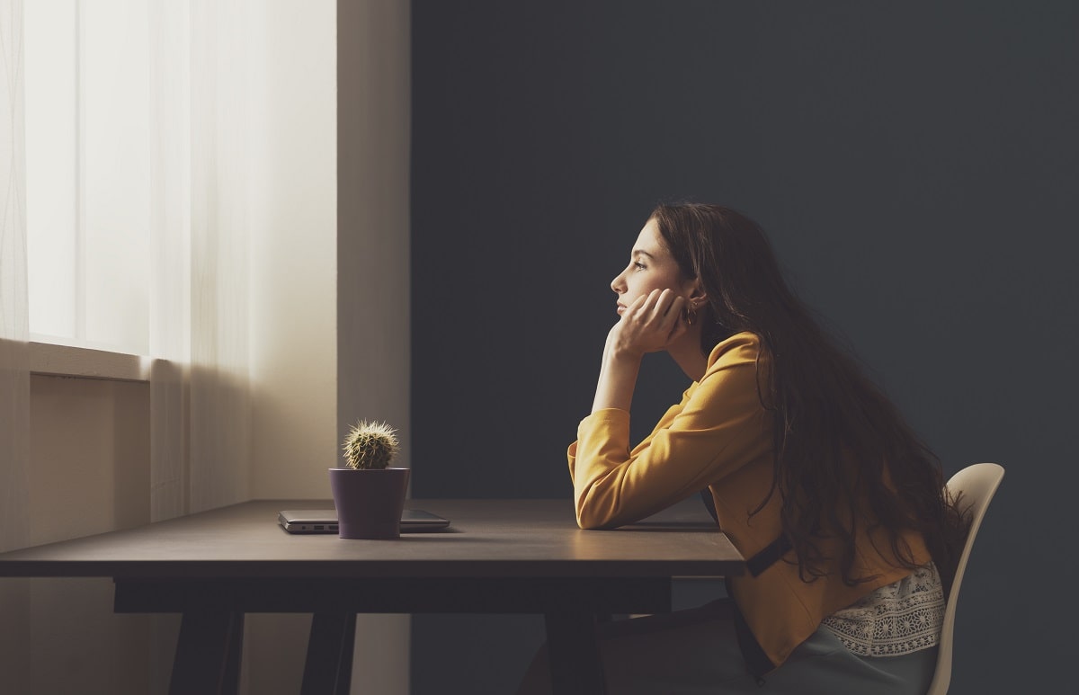 Sad lonely young woman sitting at home