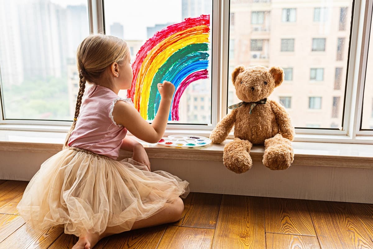 Girl Drawing a Rainbow with her crayons