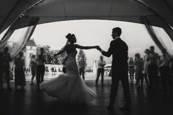 Stylish happy bride and groom gently dancing at wedding receptio