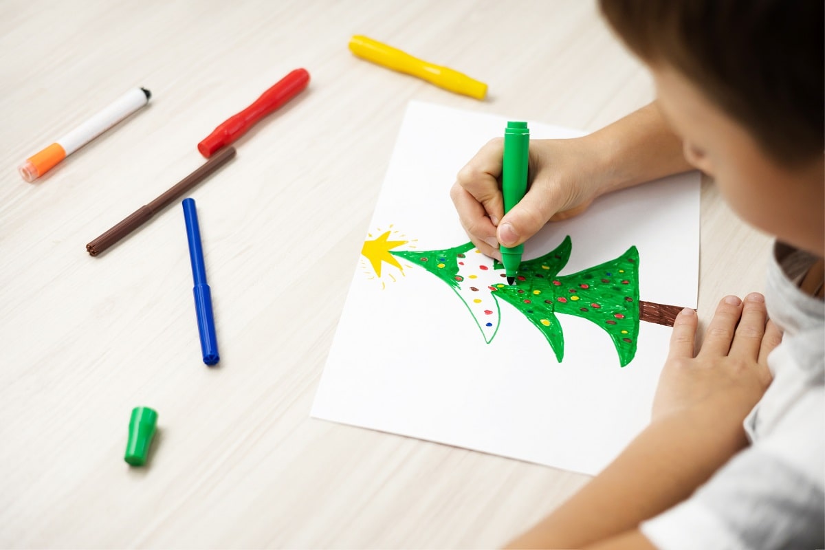 Child draw Christmas tree. Christmas holidays